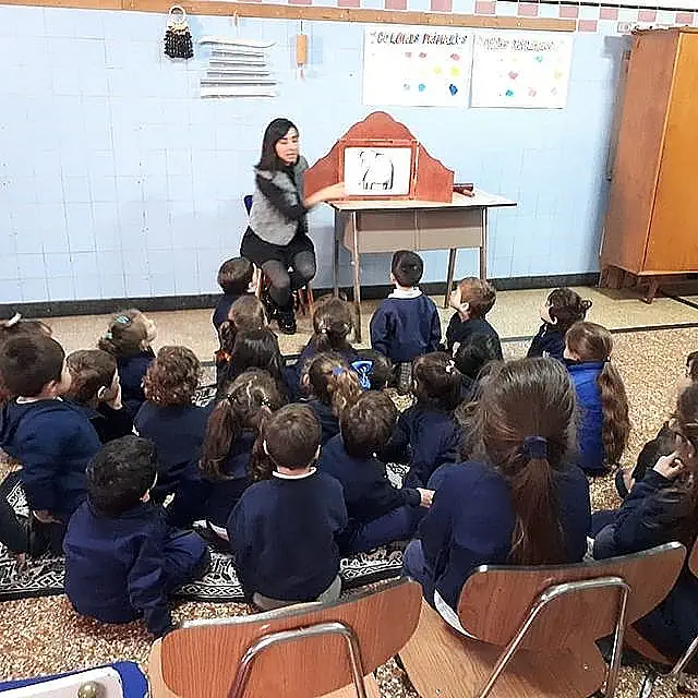 Niños de la primaria sentados en el piso recibiendo una clase especial. Prpuesta educativa del Colegio Mará Auxiliadora Boedo, Buenos Aires